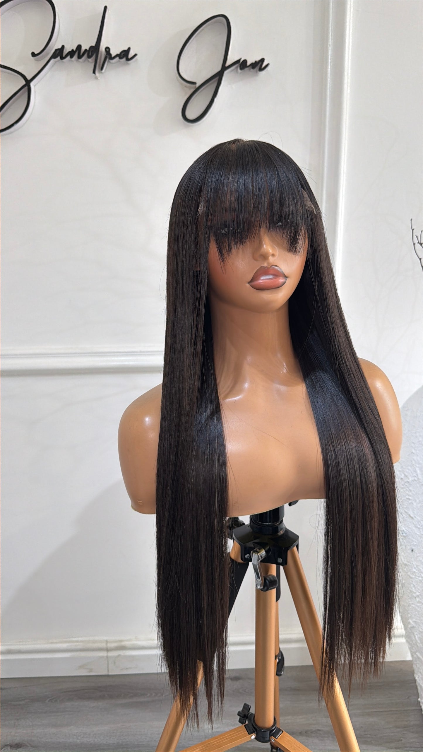 Side view of the French Bangs Raw Human Hair Wig featuring a 6x6 HD lace closure, 24-inch length and silky straight strands with elegant bangs and a natural-looking finish.