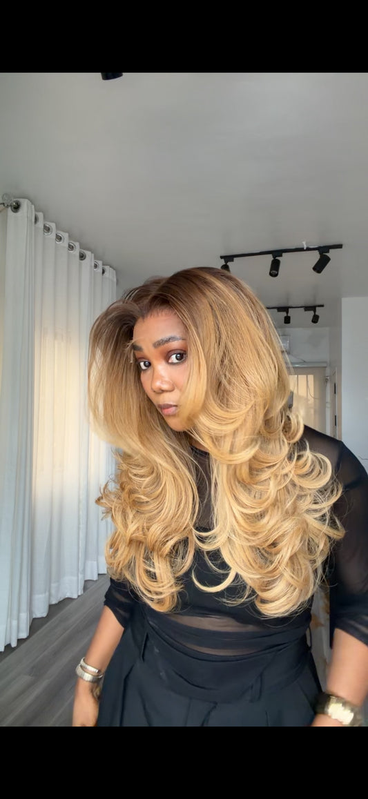 Honey Glaze layered raw human hair wig with a 6x6 HD lace closure, 20-inch wavy length, and a luxurious honey-toned finish, front view.