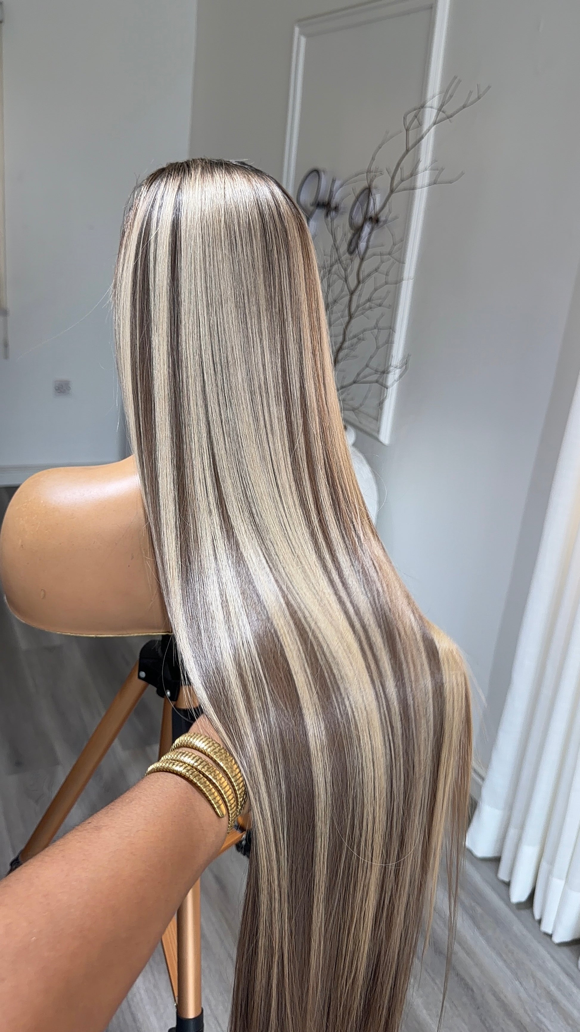 Side view of the Ice Mocha Blonde Raw Human Hair Wig featuring a 9x6 HD lace closure, 30-inch length and silky blonde strands with mocha highlights and a seamless, natural-looking hairline.