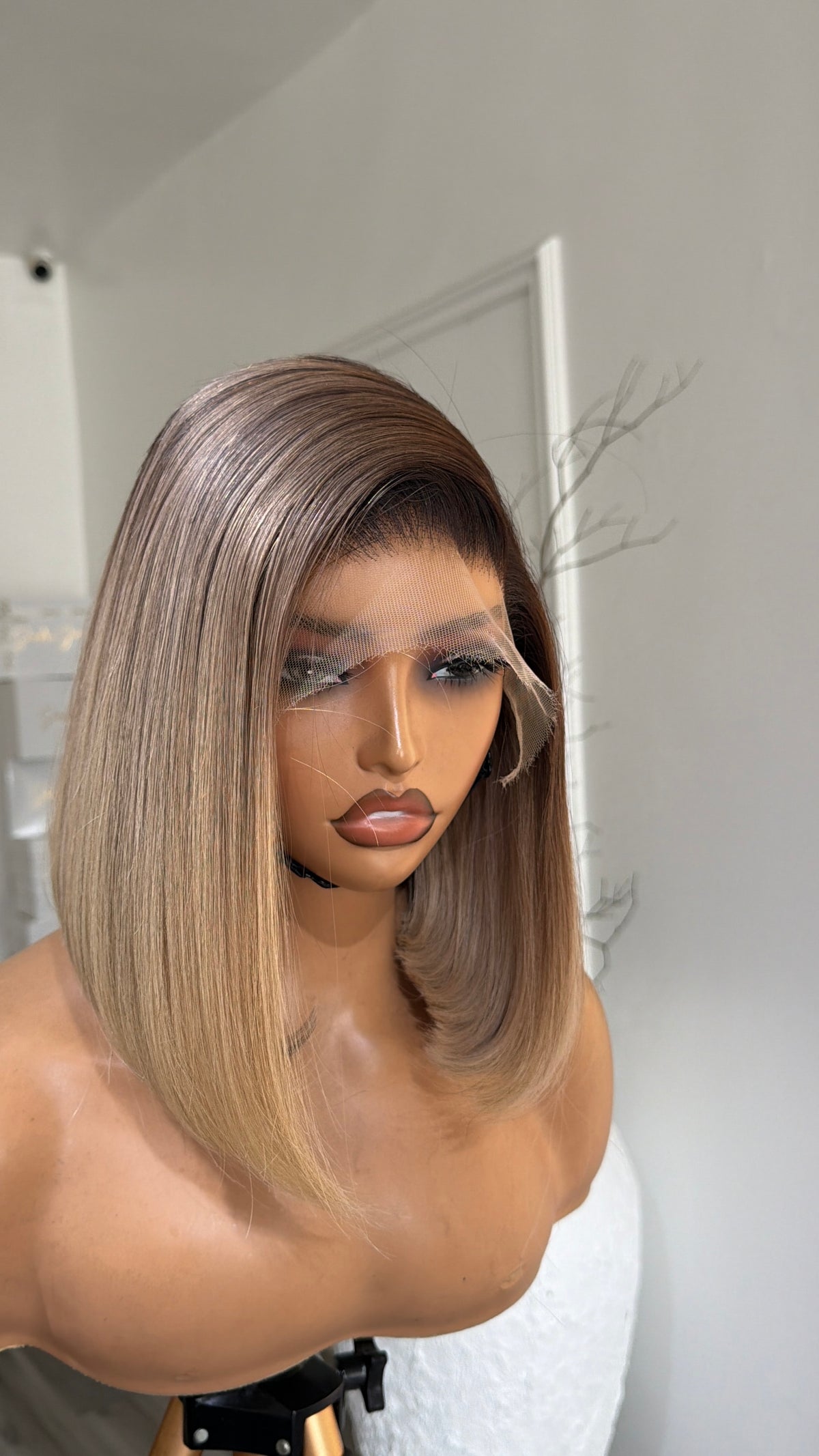 Side view of the Latte Blonde Bob Raw Human Hair Wig featuring a 9x6 HD lace closure, 10–12-inch bob length and silky latte blonde strands with a seamless, natural-looking hairline.